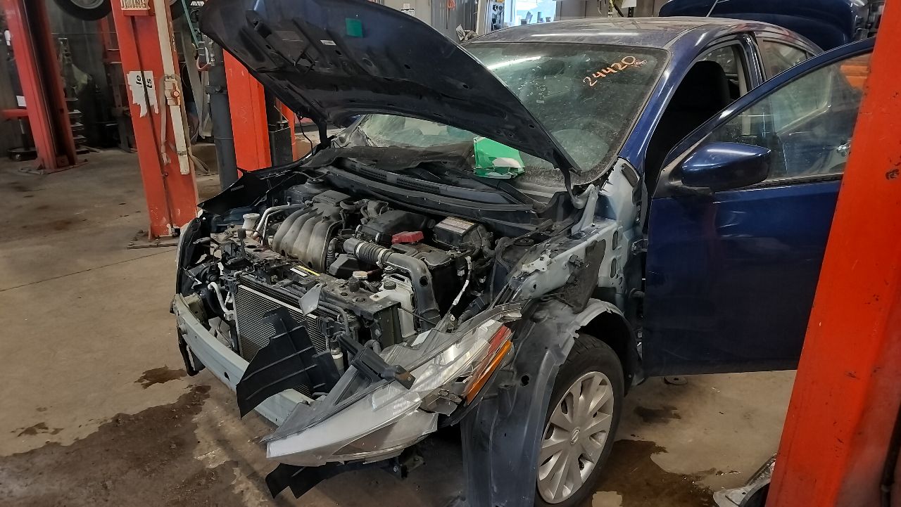 A vehicle in the shop with the hood up, engine being tested before parts are pulled